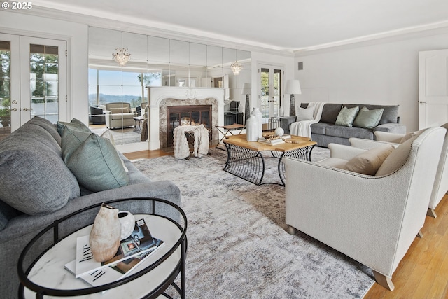 living area featuring ornamental molding, french doors, wood finished floors, and a premium fireplace