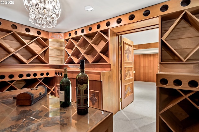 wine room with wooden walls and an inviting chandelier