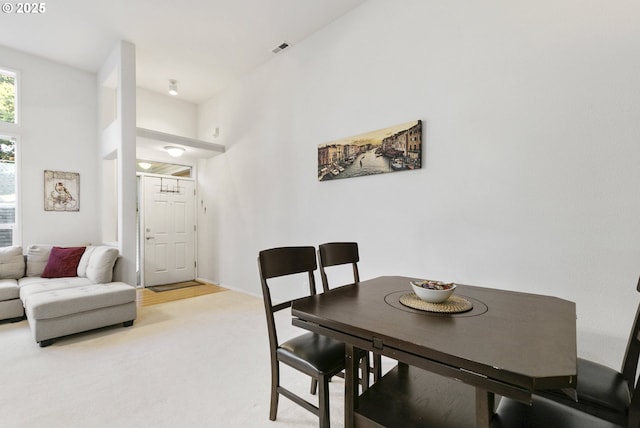 dining space featuring light carpet