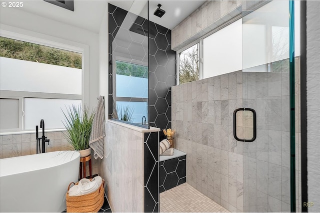 bathroom with tile walls and separate shower and tub