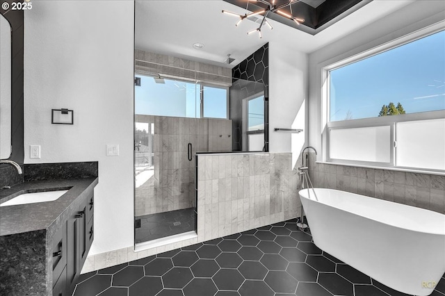 bathroom featuring tile patterned flooring, vanity, tile walls, a chandelier, and separate shower and tub