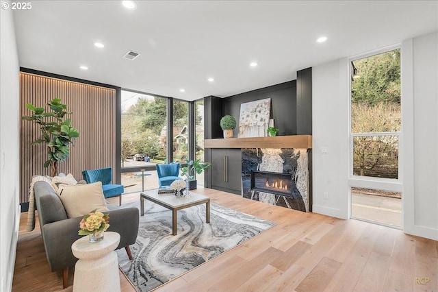 living room featuring a fireplace, floor to ceiling windows, and plenty of natural light