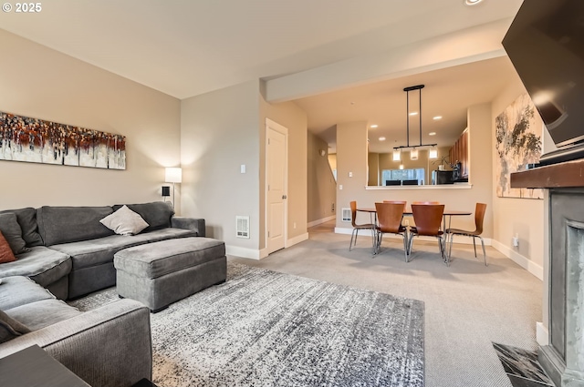 living room with a tiled fireplace and light colored carpet