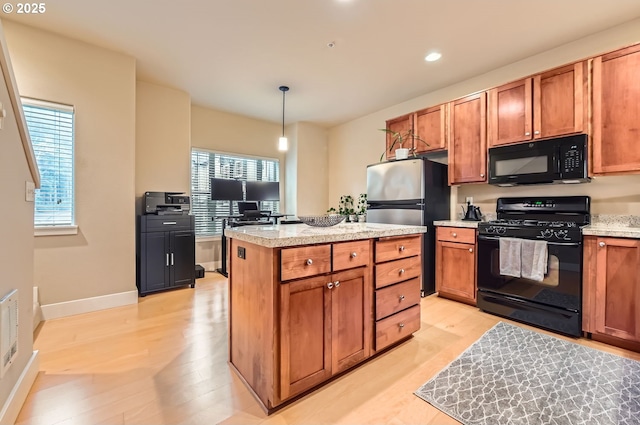 kitchen with a center island, light wood-type flooring, hanging light fixtures, and black appliances