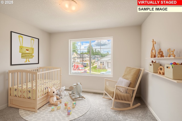 bedroom featuring a textured ceiling, carpet, and a crib