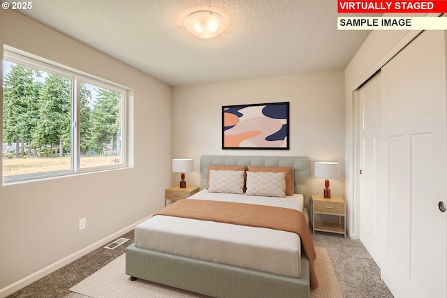 carpeted bedroom featuring a textured ceiling