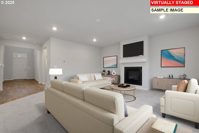 living area with recessed lighting, baseboards, and a glass covered fireplace