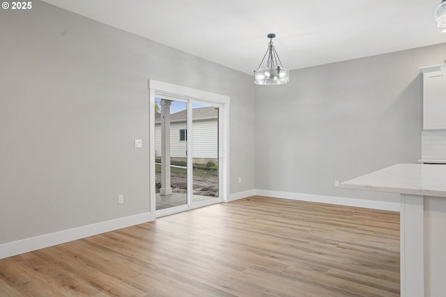 195 Iowa St, Silverton, OR 97381 - unfurnished dining area with baseboards, light wood finished floors, and a chandelier