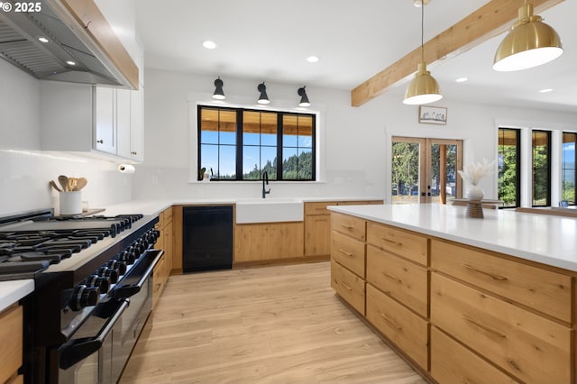 25053 Larson Rd, Monroe, OR 97456 - kitchen with wall chimney exhaust hood, gas stove, light wood-style flooring, black dishwasher, and recessed lighting