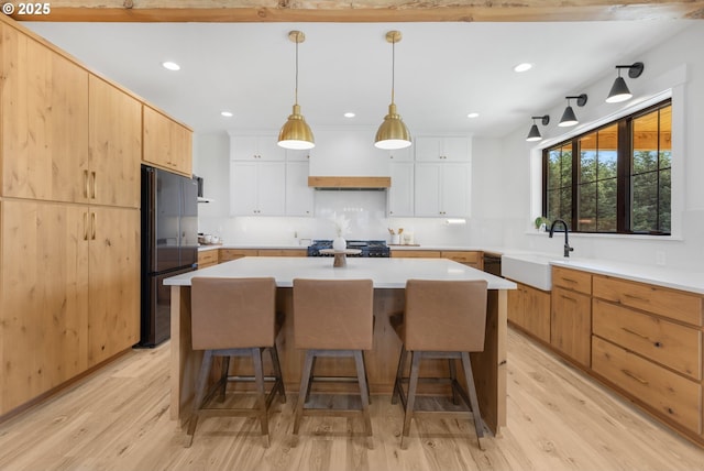25053 Larson Rd, Monroe, OR 97456 - kitchen with freestanding refrigerator, a kitchen breakfast bar, custom range hood, light wood finished floors, and recessed lighting