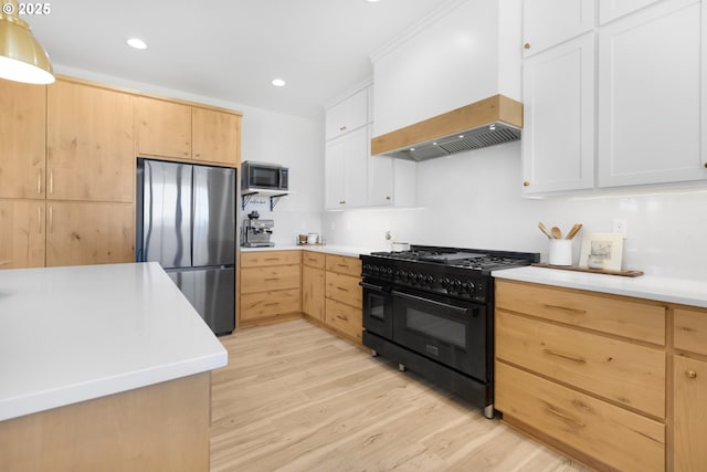 25053 Larson Rd, Monroe, OR 97456 - kitchen with appliances with stainless steel finishes, light brown cabinets, light wood-type flooring, light countertops, and custom range hood