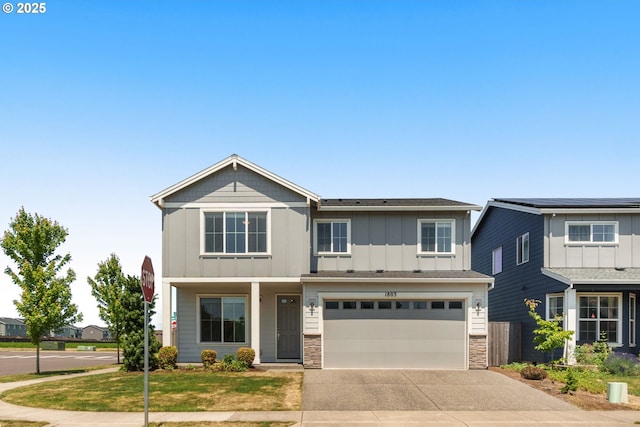 1803 35th Ave, Forest Grove, OR 97116 - view of front facade featuring board and batten siding, concrete driveway, stone siding, a garage, and a front lawn