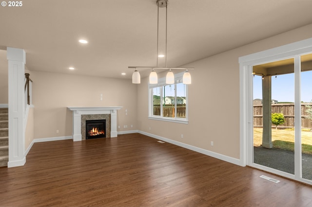 1803 35th Ave, Forest Grove, OR 97116 - unfurnished living room featuring dark wood-style flooring, recessed lighting, a warm lit fireplace, baseboards, and stairway