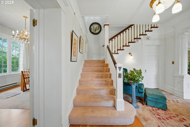 113 NE 7th Ave, Milton-Freewater, OR 97862 - stairs featuring decorative columns, a chandelier, wood finished floors, and a baseboard heating unit