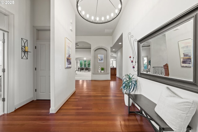 hall featuring a chandelier and dark wood-type flooring