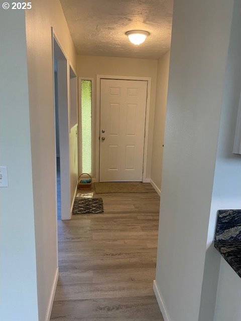 82277 Davisson Rd, Creswell, OR 97426 - hall with wood finished floors, baseboards, and a textured ceiling