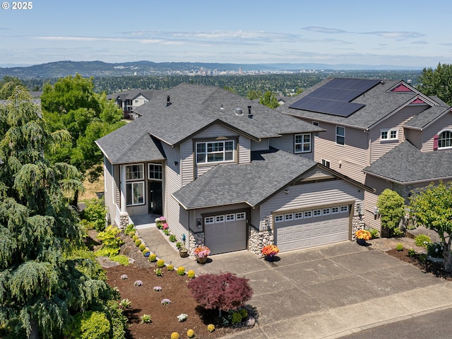 8833 SE Bristol Park Dr, Happy Valley, OR 97086 - view of front of house with roof with shingles, concrete driveway, an attached garage, stone siding, and a mountain view