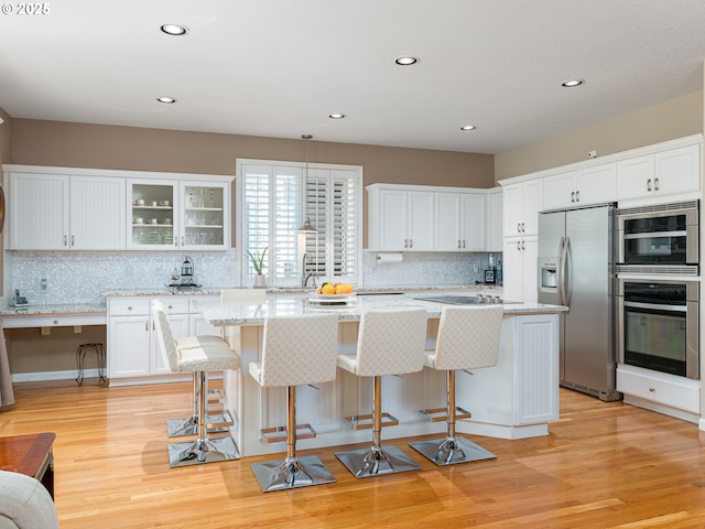 8833 SE Bristol Park Dr, Happy Valley, OR 97086 - kitchen featuring appliances with stainless steel finishes, a kitchen island, tasteful backsplash, white cabinetry, and recessed lighting
