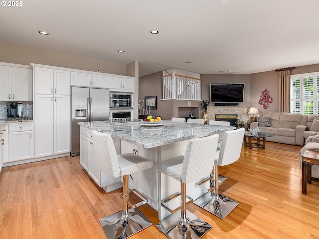 8833 SE Bristol Park Dr, Happy Valley, OR 97086 - kitchen with appliances with stainless steel finishes, light wood-type flooring, white cabinets, and recessed lighting