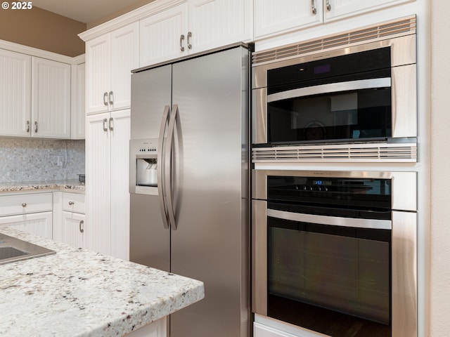 8833 SE Bristol Park Dr, Happy Valley, OR 97086 - kitchen with stainless steel fridge, white cabinets, backsplash, and light stone counters
