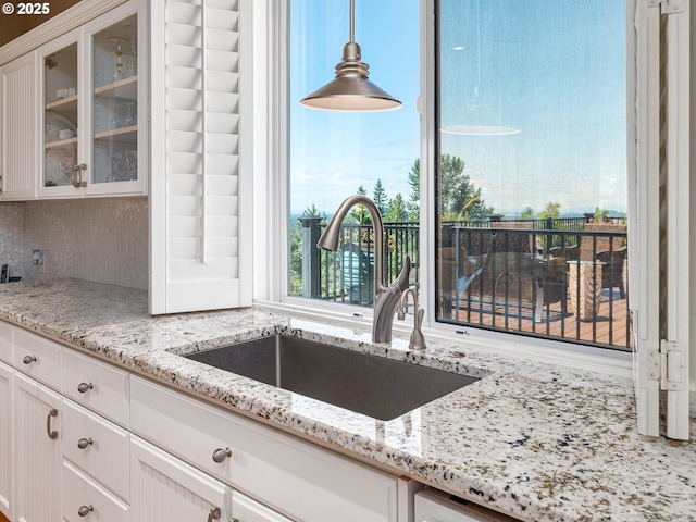 8833 SE Bristol Park Dr, Happy Valley, OR 97086 - kitchen featuring glass insert cabinets, white cabinets, tasteful backsplash, and light stone counters