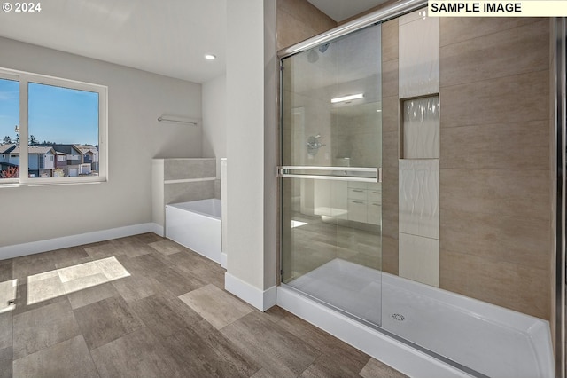 12343 SE Falling Rain Way, Happy Valley, OR 97086 - bathroom featuring a shower stall, a garden tub, recessed lighting, and wood finished floors