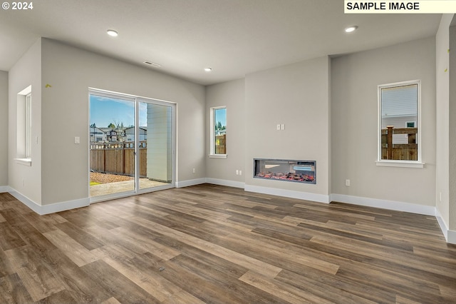 12343 SE Falling Rain Way, Happy Valley, OR 97086 - unfurnished living room featuring wood finished floors, recessed lighting, and a glass covered fireplace