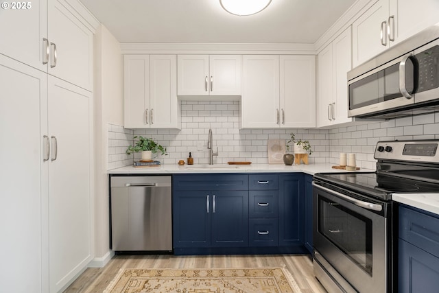 10258 N Allegheny Ave, Portland, OR 97203 - kitchen with appliances with stainless steel finishes, a sink, light wood-style floors, and white cabinetry