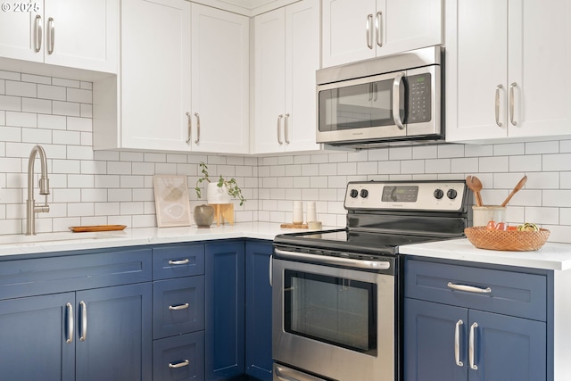10258 N Allegheny Ave, Portland, OR 97203 - kitchen with stainless steel appliances, blue cabinetry, a sink, and white cabinets