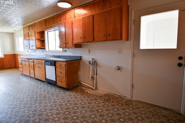 151 NW Sherry St, Winston, OR 97496 - kitchen featuring sink, wooden walls, dishwashing machine, and a textured ceiling