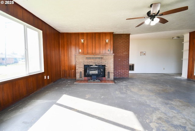 151 NW Sherry St, Winston, OR 97496 - unfurnished living room featuring ceiling fan, wooden walls, and a wood stove