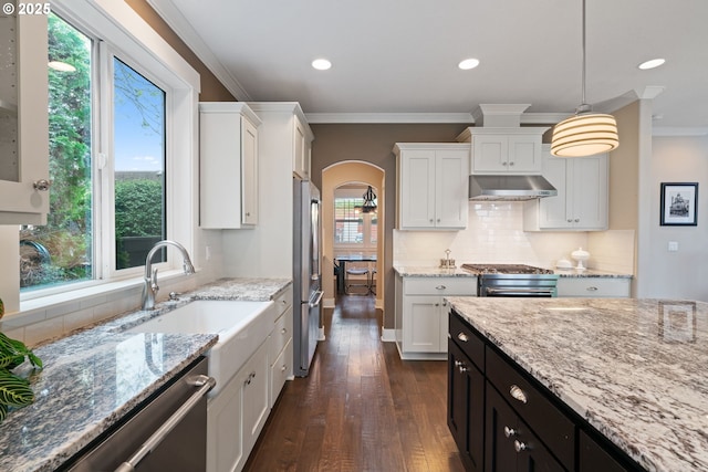 kitchen featuring arched walkways, white cabinetry, dark wood-style floors, and stainless steel appliances