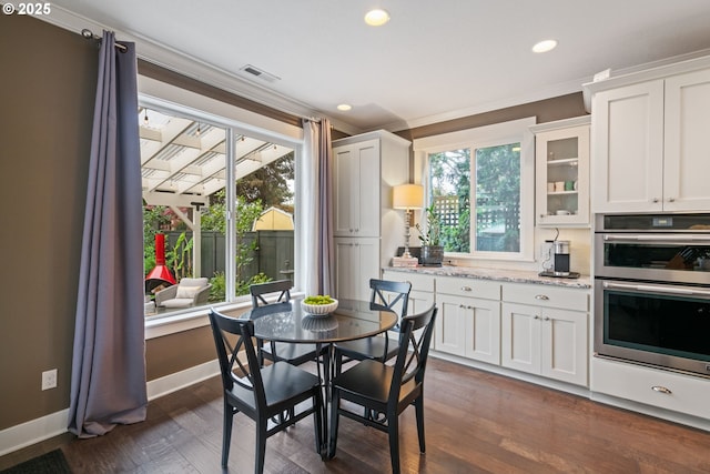 kitchen with crown molding, glass insert cabinets, recessed lighting, stainless steel double oven, and white cabinetry