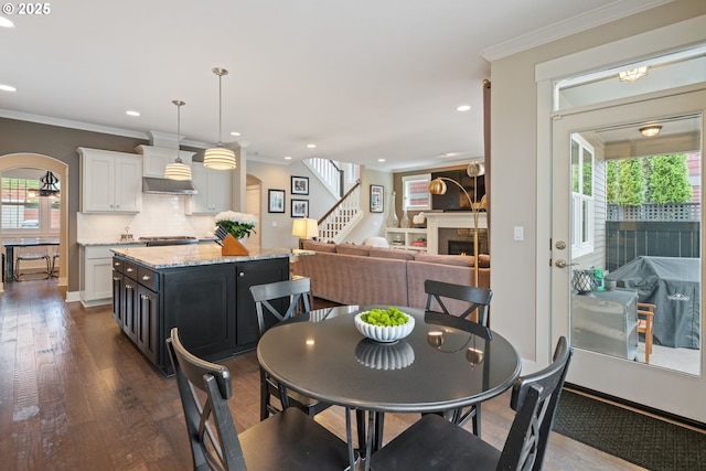 dining area featuring crown molding and dark wood finished floors