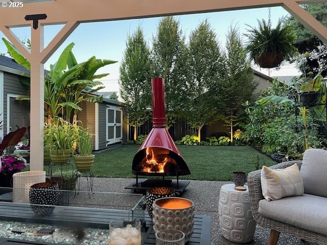 view of yard with an outbuilding, a fire pit, and a patio