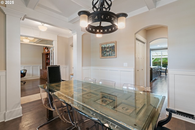 dining space with arched walkways, wainscoting, dark wood finished floors, beamed ceiling, and a decorative wall