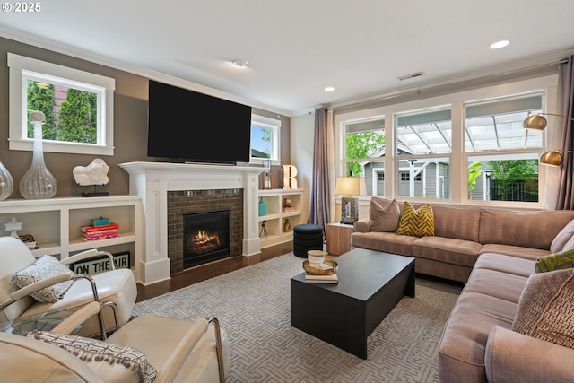 living room with ornamental molding, a fireplace, recessed lighting, and visible vents