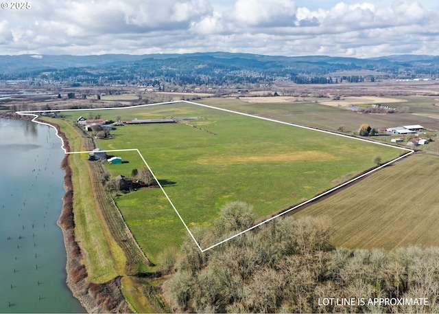 drone / aerial view with a water and mountain view and a rural view