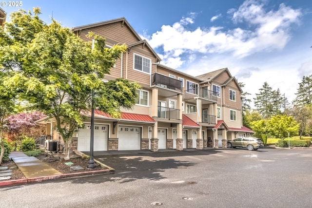 view of property with central AC, driveway, and a garage