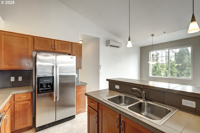 kitchen with stainless steel fridge, a wall unit AC, a sink, brown cabinets, and lofted ceiling