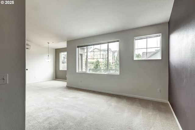 unfurnished room featuring carpet floors, baseboards, and an AC wall unit
