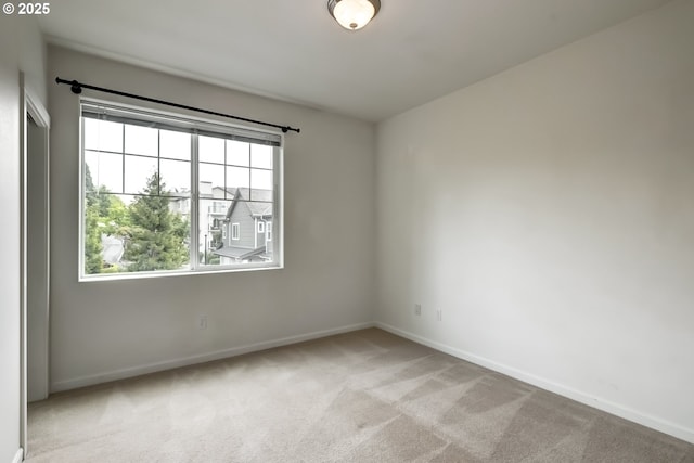 empty room with baseboards and light colored carpet