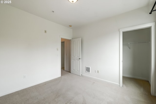 unfurnished bedroom with carpet flooring, baseboards, a closet, and a spacious closet