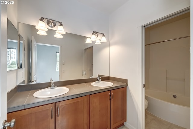 bathroom featuring double vanity, tile patterned floors, toilet, and bathtub / shower combination