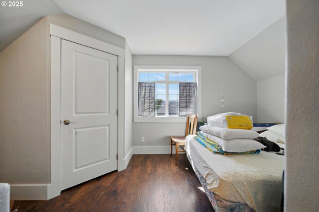 bedroom featuring baseboards, vaulted ceiling, and hardwood / wood-style floors