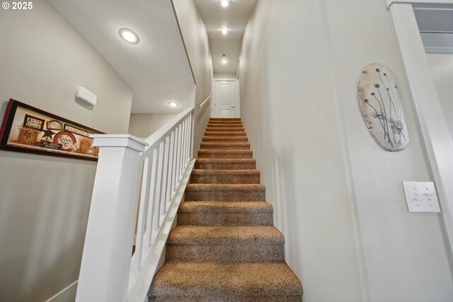 staircase featuring recessed lighting