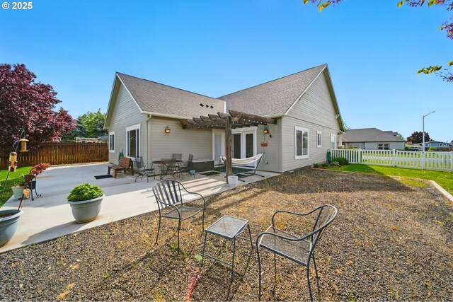 back of house with a pergola, a shingled roof, a fenced backyard, and a patio area
