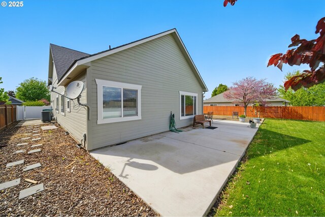 back of property with a patio, a fenced backyard, a yard, and cooling unit