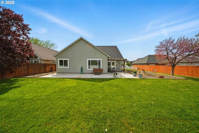 back of house featuring a lawn, a fenced backyard, and a patio area