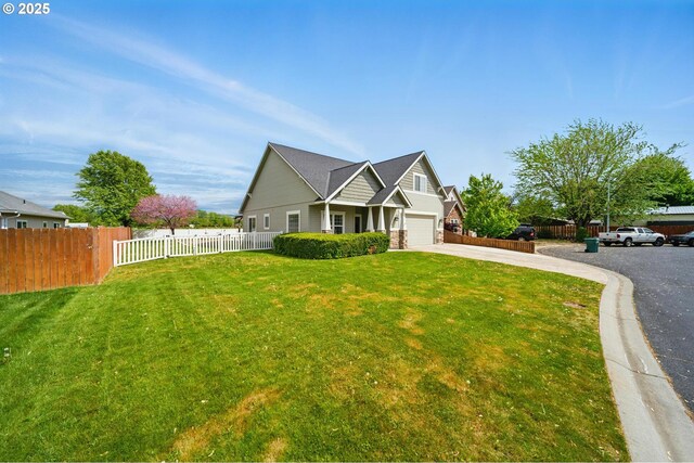 craftsman inspired home featuring an attached garage, a front lawn, fence, and driveway